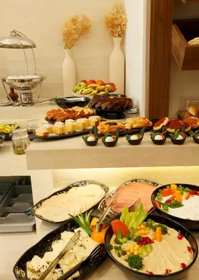 a table with many plates of food on it at G Hotel Amman in Amman