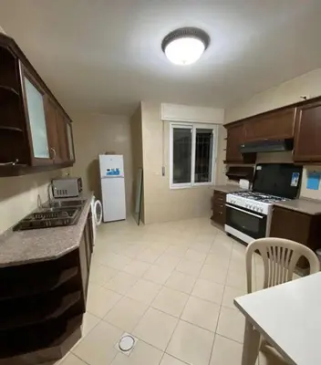a kitchen with a stove and a refrigerator at Apartment in Amman Khalda in Amman