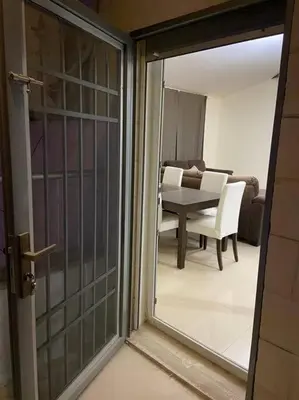a view of a living room with a table and chairs at Apartment in Amman Khalda in Amman