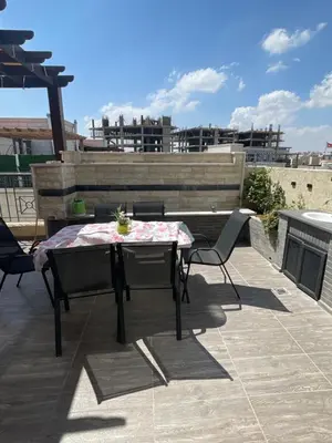a patio with a table and chairs on a roof at Modern Rooftop apartment in Amman