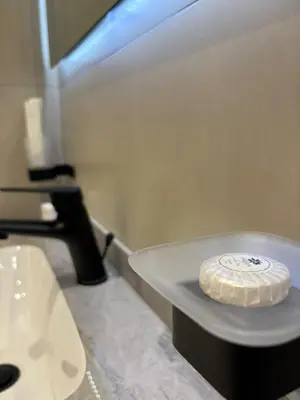 a bathroom with a sink and a white toilet at Nozoll Boutique Residences in Amman