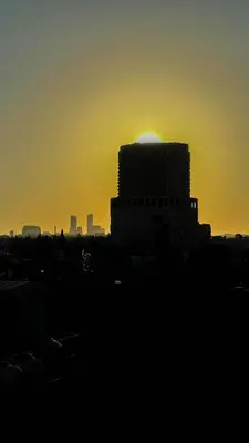 a building with the sun setting in the background at Nozoll Boutique Residences in Amman