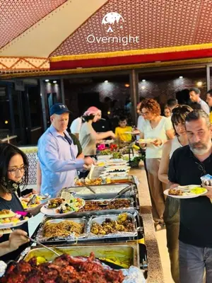 a group of people standing around a buffet of food at Rum Overnight luxury& jeep in Wadi Rum