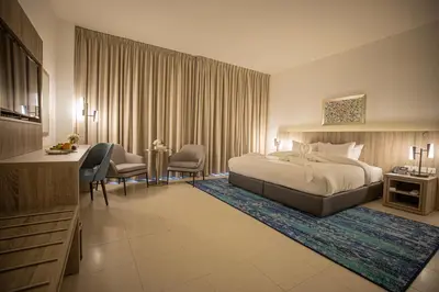 a hotel room with a bed and a desk at Golden Tulip Amman in Amman