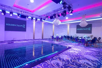 a banquet hall with tables and chairs and a pool at Golden Tulip Amman in Amman