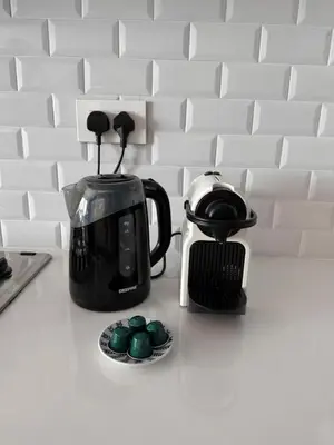 a kitchen counter with a tea kettle and cupcakes at Chic One-Bedroom with Sea View in Aqaba