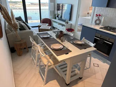 a kitchen and living room with a table and chairs at Chic One-Bedroom with Sea View in Aqaba