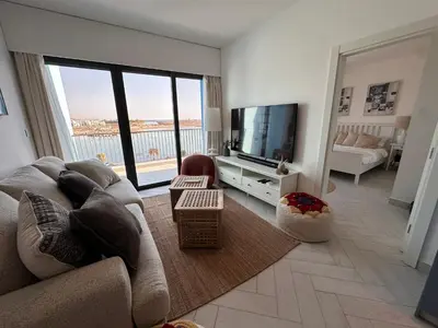 a living room with a couch and a flat screen tv at Chic One-Bedroom with Sea View in Aqaba