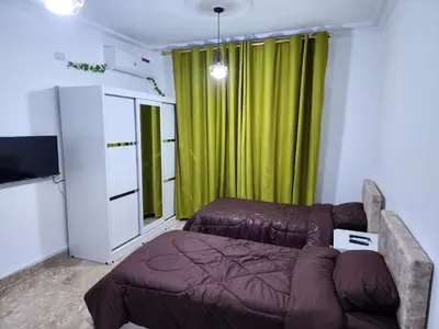 a living room with a couch and a green curtain at Salo StudioS in Amman