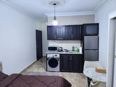 a small kitchen with black cabinets and a stove at Salo StudioS in Amman