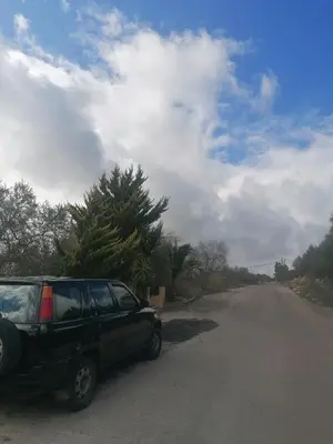 a black suv parked on the side of a road at روابي عجلون منزل in Ajloun
