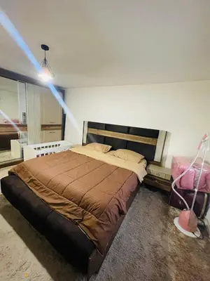 a bedroom with a large bed in a room at Cozy 2 bedroom apartment in Amman