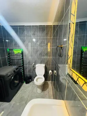 a bathroom with a toilet and a sink at Cozy 2 bedroom apartment in Amman