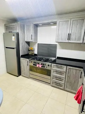 a kitchen with a stove and a refrigerator at Cozy 2 bedroom apartment in Amman