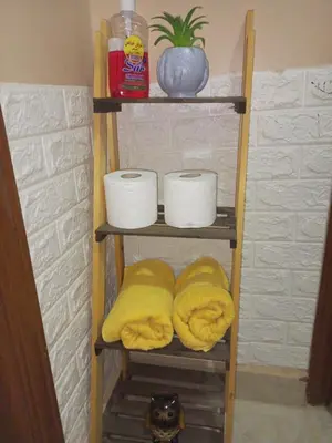 a wooden shelf with dishes and towels on it at luxury house in Madaba