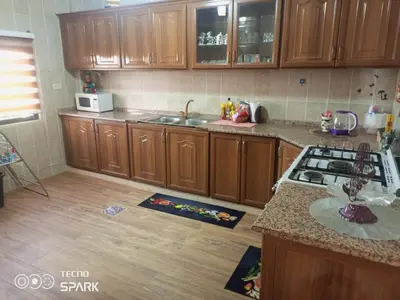 a kitchen with wooden cabinets and a counter top at luxury house in Madaba