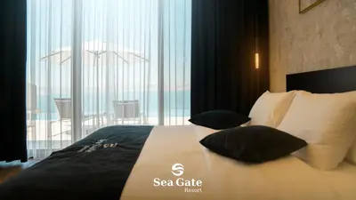 a hotel room with a bed with black and white pillows at Sea Gate Resort in Sowayma