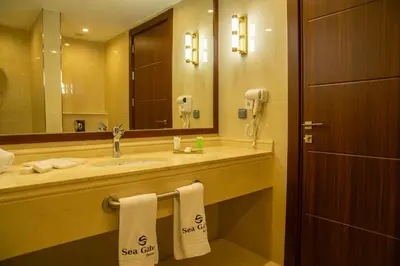 a bathroom with a sink and a mirror and towels at Sea Gate Resort in Sowayma