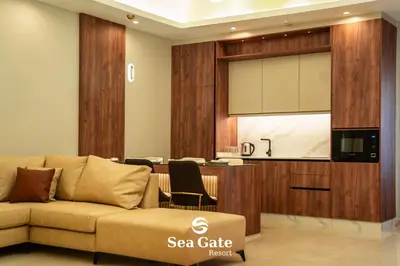 a living room with a couch and a kitchen at Sea Gate Resort in Sowayma