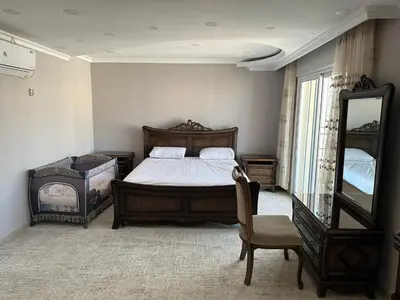 a bedroom with a bed and a mirror and a chair at شقه في اربد apartment in irbid in Irbid