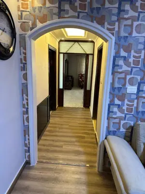 a hallway leading into a room with a clock on a wall at شقه في اربد apartment in irbid in Irbid