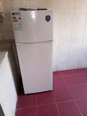 a white refrigerator in a room with purple tiles at شقة ام نوارة الحديثة الفارهة spacious economic flat in Amman