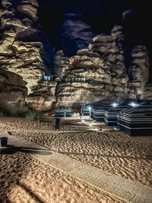 a beach at night with a rock wall at Aladdin Camp in Disah