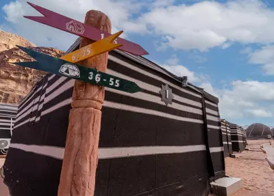 a pole with street signs on it next to a building at Aladdin Camp in Disah