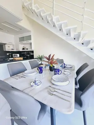 a white dining table with blue and white dishes on it at B36 Loft Apartment Samarah Resort in Sowayma