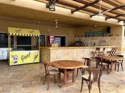 a restaurant with tables and chairs in front of a counter at B35 Samarah Resort LOFT apartment in Sowayma