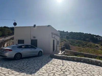 a white car parked next to a white building at منزل مستقل لقضاء اجمل الاوقات بجبال عجلون in Ajloun