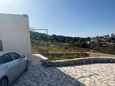 a car parked next to a building with a stone driveway at منزل مستقل لقضاء اجمل الاوقات بجبال عجلون in Ajloun