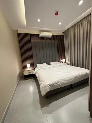 a bedroom with a large white bed with two night stands at Chic Apartments For Rent ave2-1 in Amman