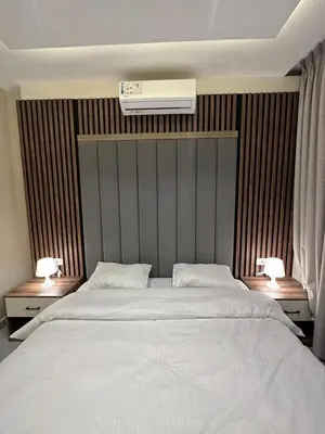 a bedroom with a large white bed with two lamps at Chic Apartments For Rent ave2-1 in Amman