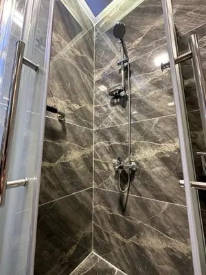 a shower with a glass door in a bathroom at Chic Apartments For Rent ave2-1 in Amman