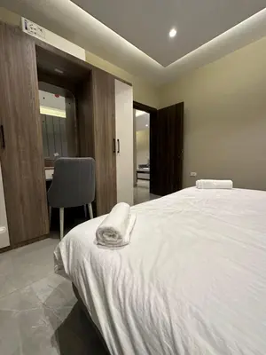 a bedroom with a white bed and a chair at Chic Apartments For Rent ave2-2 in Amman