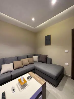 a living room with a couch and a table at Chic Apartments For Rent ave2-2 in Amman