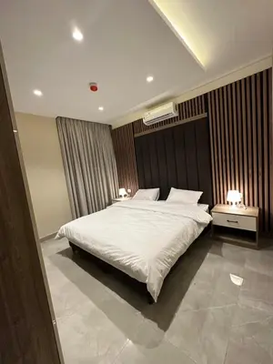 a bedroom with a large white bed with two lamps at Chic Apartments For Rent ave2-4 in Amman