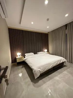a bedroom with a large white bed with two lamps at Chic Apartments For Rent ave2-5 in Amman