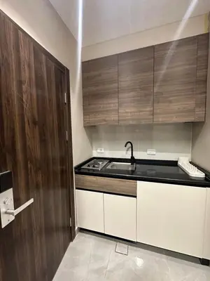 a kitchen with a sink and wooden cabinets at Chic Apartments For Rent ave2-7 in Amman