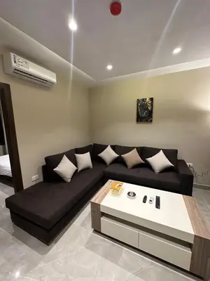 a living room with a black couch and a table at Chic Apartments For Rent ave2-8 in Amman