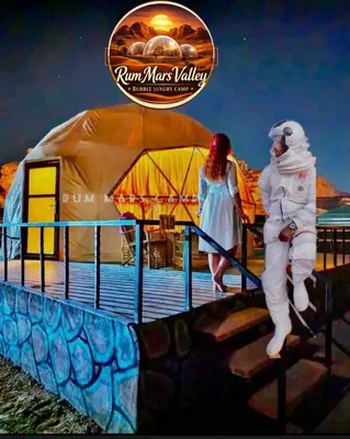 a man and a woman standing on a pier at RUM MARS VALLEY BUBBLE lUXURY CAMP in Wadi Rum