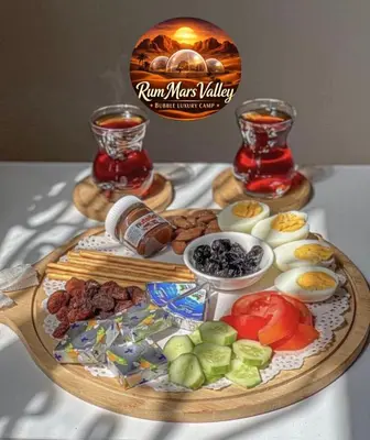 a tray of food on a table with two glasses of tea at RUM MARS VALLEY BUBBLE lUXURY CAMP in Wadi Rum