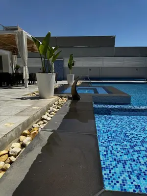 a swimming pool next to a house at Maui Villa by Seahorse in Al Rama