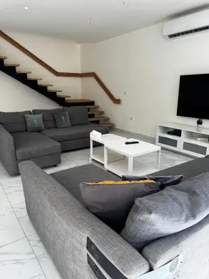a living room with a couch and a table at Maui Villa by Seahorse in Al Rama