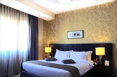 a bedroom with a large bed with two pillows at City Rose Hotel Suites in Amman