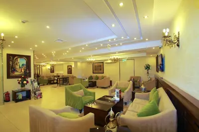 a living room with couches and chairs in a room at City Rose Hotel Suites in Amman