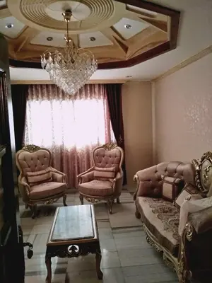 a living room with two chairs and a chandelier at zin home in ‘Awjān ash Sharqī