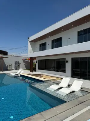 a house with a swimming pool with white lounge chairs at Sol Villa By Seahorse in Al Rama
