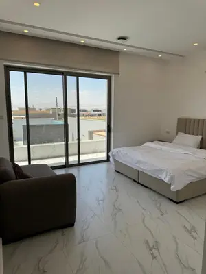 a bedroom with a bed and a couch and a large window at Sol Villa By Seahorse in Al Rama